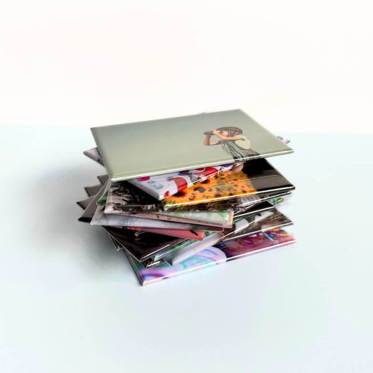 Image shows a stack of rectangle photo magnets piled upon one another unevenly.